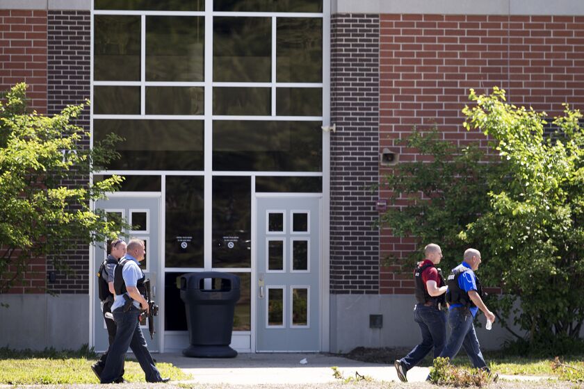 FILE - Law enforcement officers walk outside Noblesville West Middle School in Noblesville, Ind., after a shooting, May 25, 2018. A judge on Wednesday, June 7, 2023, ordered a former student who opened fire at the Indiana middle school in 2018, wounding another student and a teacher, to remain in custody until an investigation of a separate assault allegation is completed. (Robert Scheer/The Indianapolis Star via AP, File)