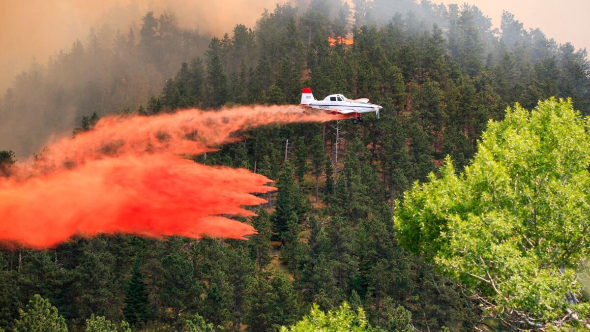 A plane drops retardant on a wildfire near the historic mining town of Landusky, south of the Fort Belknap Indian Reservation in north-central Montana. (Meg Oliphant / Associated Press)