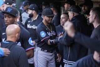 Miami Marlins' Luis Arraez, center, shakes hands with teammates in the dugout after being traded to the San Diego Padres before the team's baseball game against the Oakland Athletics, Friday, May 3, 2024, in Oakland, Calif. (AP Photo/Godofredo A. Vásquez)