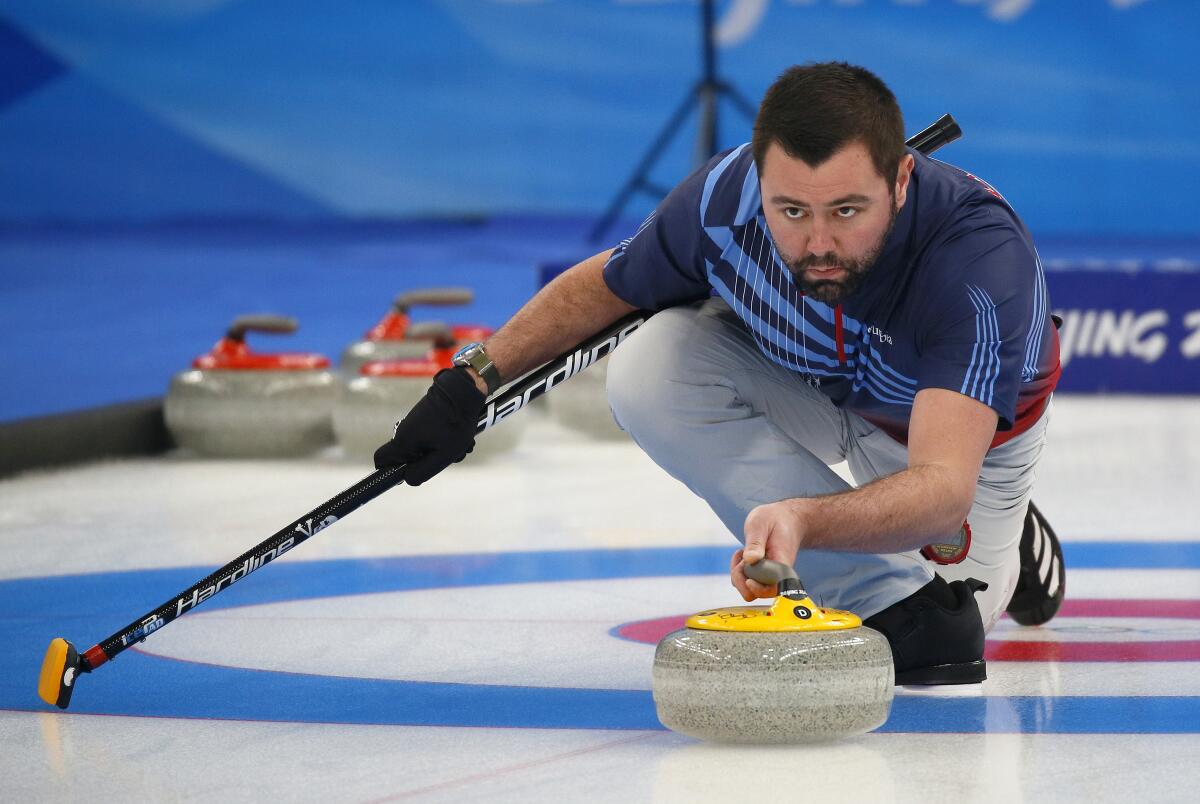 An intense John Landsteiner from the U.S. Olympic Curling team prepares to release the curling stone.