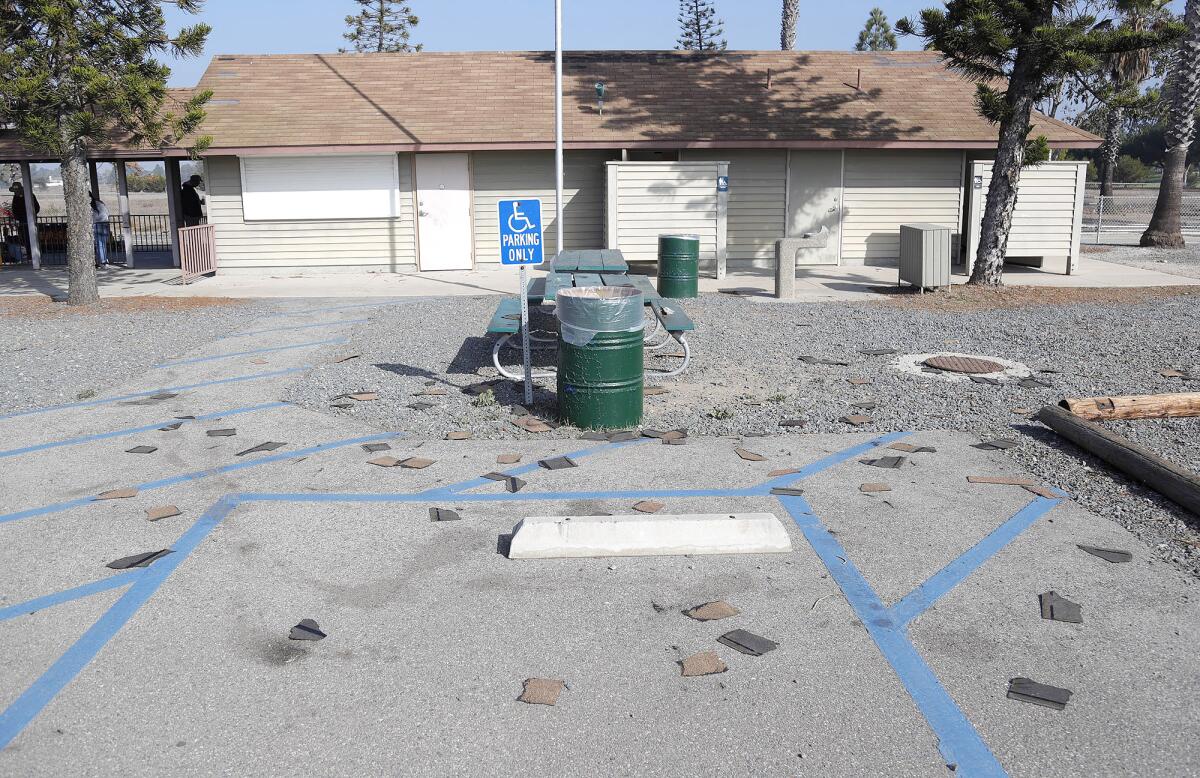 Roof shingles strewn about the parking lot of the  O.C. Model Engineers facility at Costa Mesa's Fairview Park on Wednesday. 