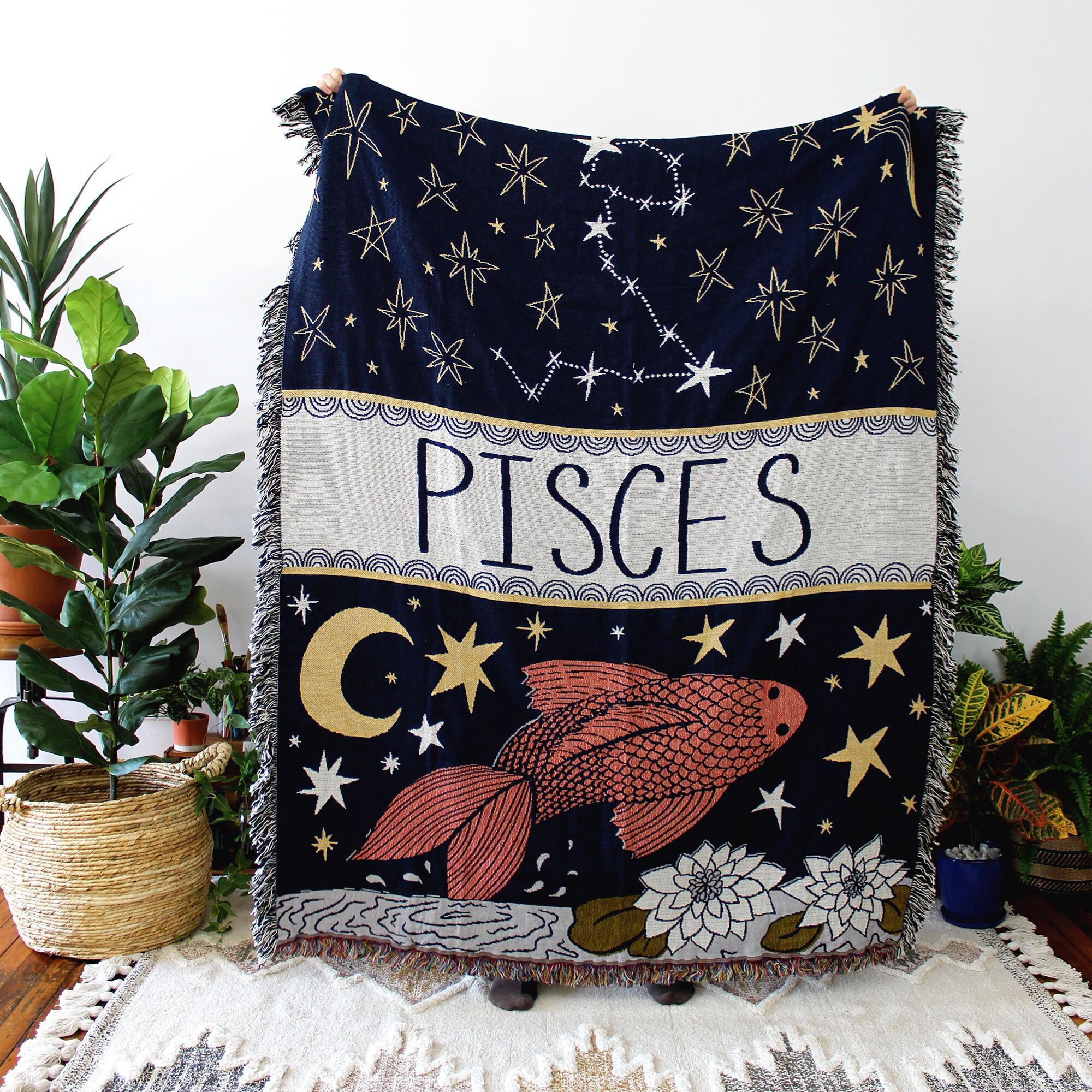 A blanket with the word "Pisces" and a drawing of a fish and stars   