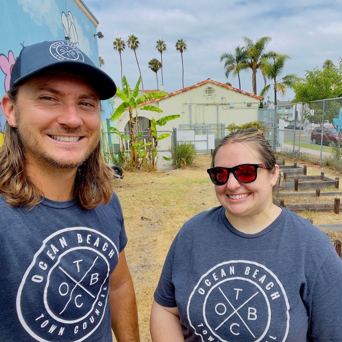 Ocean Beach Town Council members Cameron Reid and Stephanie Logan clean up the Ocean Beach Elementary School grounds Aug. 21.
