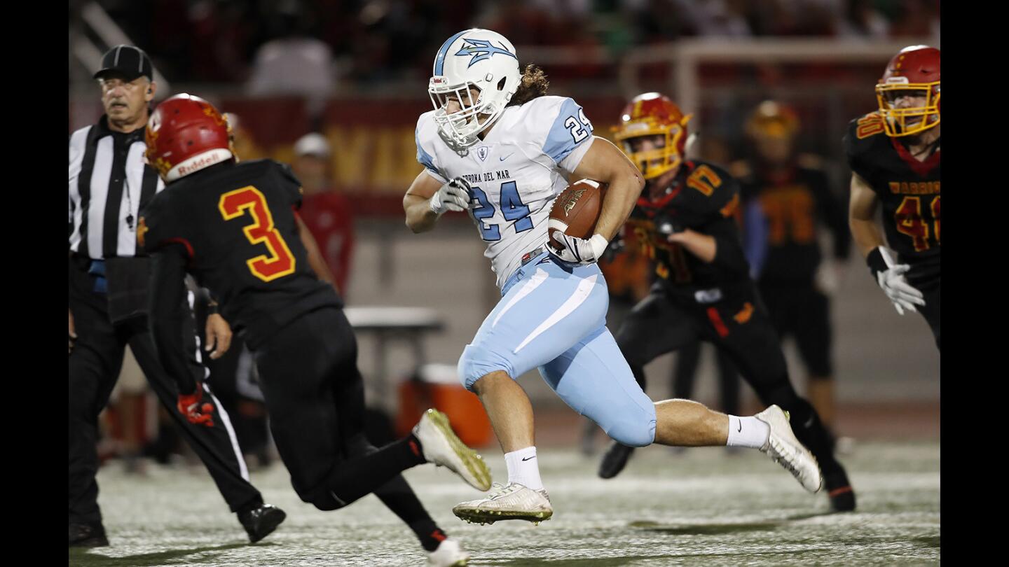 Corona del Mar High’s Alex Pourdanesh (24) rushes for a first down during the first half against Woodbridge in the Pacific Coast League championship game at University High School in Irvine on Friday, Nov. 3.