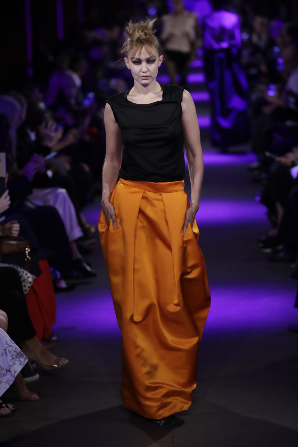 A look from the spring and summer 2020 Tom Ford runway collection: a simple black top and slouchy orange skirt