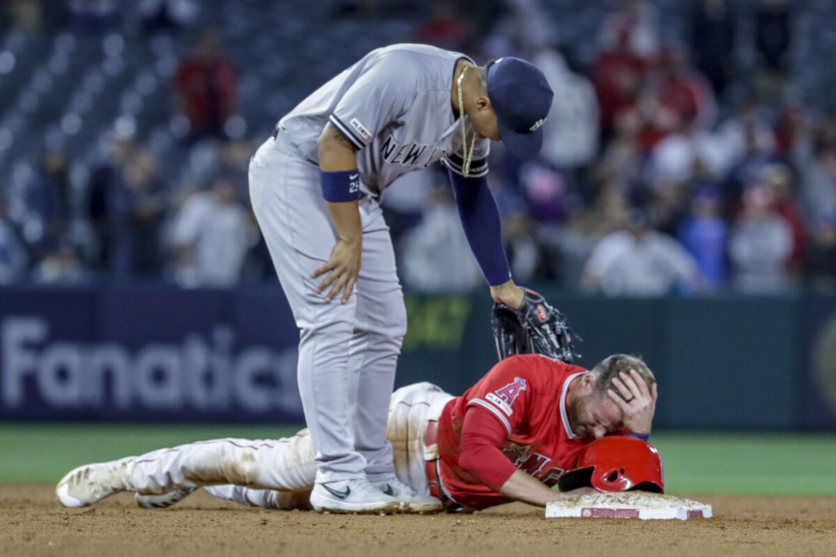 Angels third baseman Zack Cozart lays at second base after hurting his head on a 12th-inning game-tying single by Brian Goodwin at Angel Stadium on Tuesday,