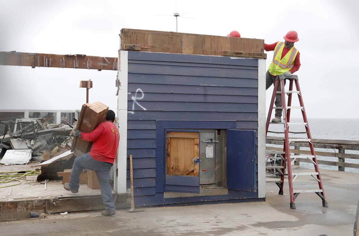 Workers dismantle the last wall panel of the restaurant.