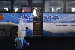 Workers in protective gear disinfect an Olympic shuttle bus ahead of the 2022 Winter Olympics, Sunday, Jan. 30, 2022, in Zhangjiakou, China. (AP Photo/Jae C. Hong)