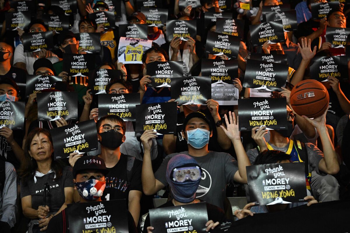 Protesters shout slogans as they hold flyers during a rally in Hong Kong in support of Rockets general manager Daryl Morey on Tuesday.