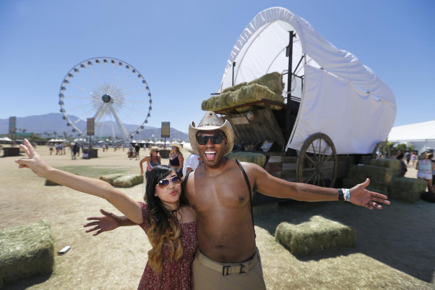 Jenn Nguyen and Amahl Harris, both of Santa Barbara, pose in front of a giant covered wagon and La Grande XL Ferris wheel on the third day of the Stagecoach country music festival at the Empire Polo Fields in Indio, Calif., on April 30, 2017.