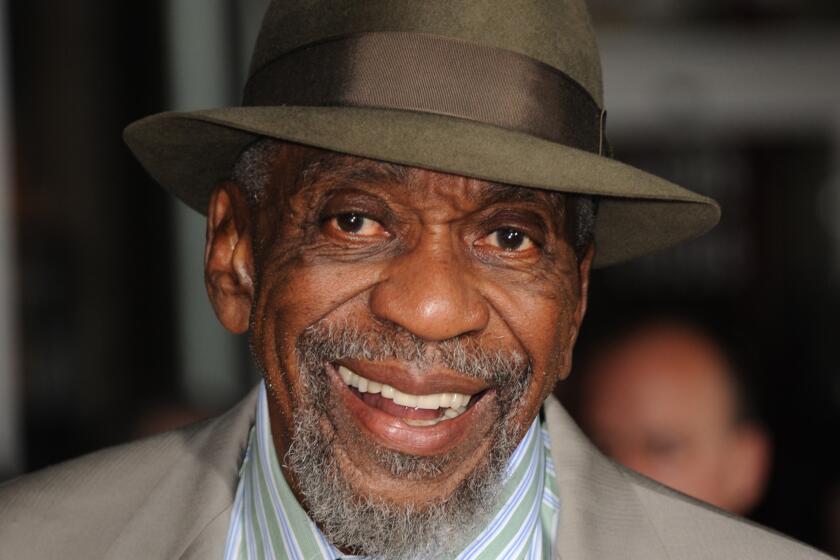 Bill Cobbs in taupe suit, green striped shirt, and fedora at the 2023 premiere of "Oz The Great and Powerful"