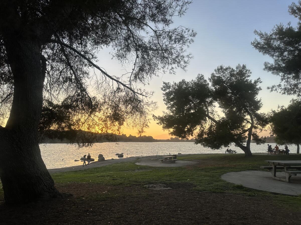 People stand near the lake on Labor Day at Frank G. Bonelli Regional Park in San Dimas.