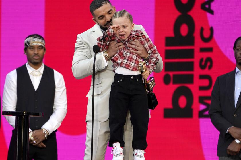 Drake carries his son Adonis Graham as he accepts the artist of the decade award at the Billboard Music Awards on Sunday, May 23, 2021, at the Microsoft Theater in Los Angeles. (AP Photo/Chris Pizzello)