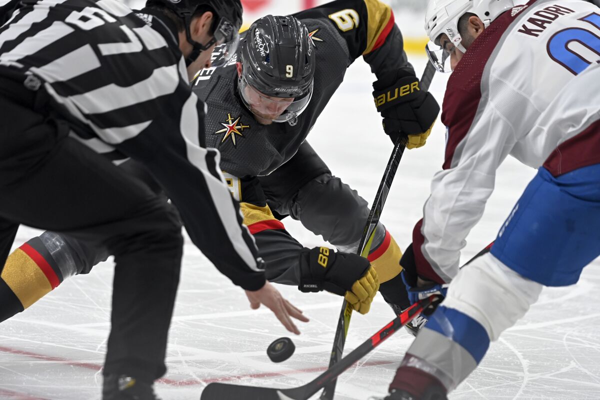 Vegas Golden Knights center Jack Eichel (9) and Colorado Avalanche center Nazem Kadri (91) face off during the second period of an NHL hockey game Wednesday, Feb. 16, 2022, in Las Vegas. (AP Photo/David Becker)