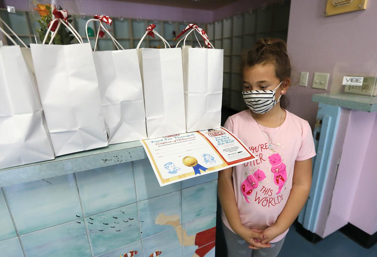 First-grader McKinley Costales waits to receive one of the Valentine's Day bags.