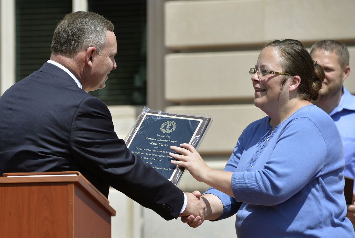 Pastor Jeffrey Fugate gives an award to Rowan County Clerk Kim Davis during a Religious Freedoms Rally at the Kentucky State Capitol on Aug. 22. Davis has been sued by The American Civil Liberties Union for denying marriage licenses to same-sex couples.