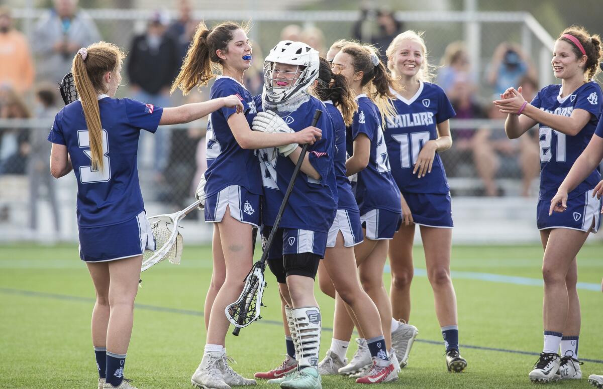 Newport Harbor girls' lacrosse players celebrate their 13-7 win over Corona del Mar during a Sunset League match on Tuesday.