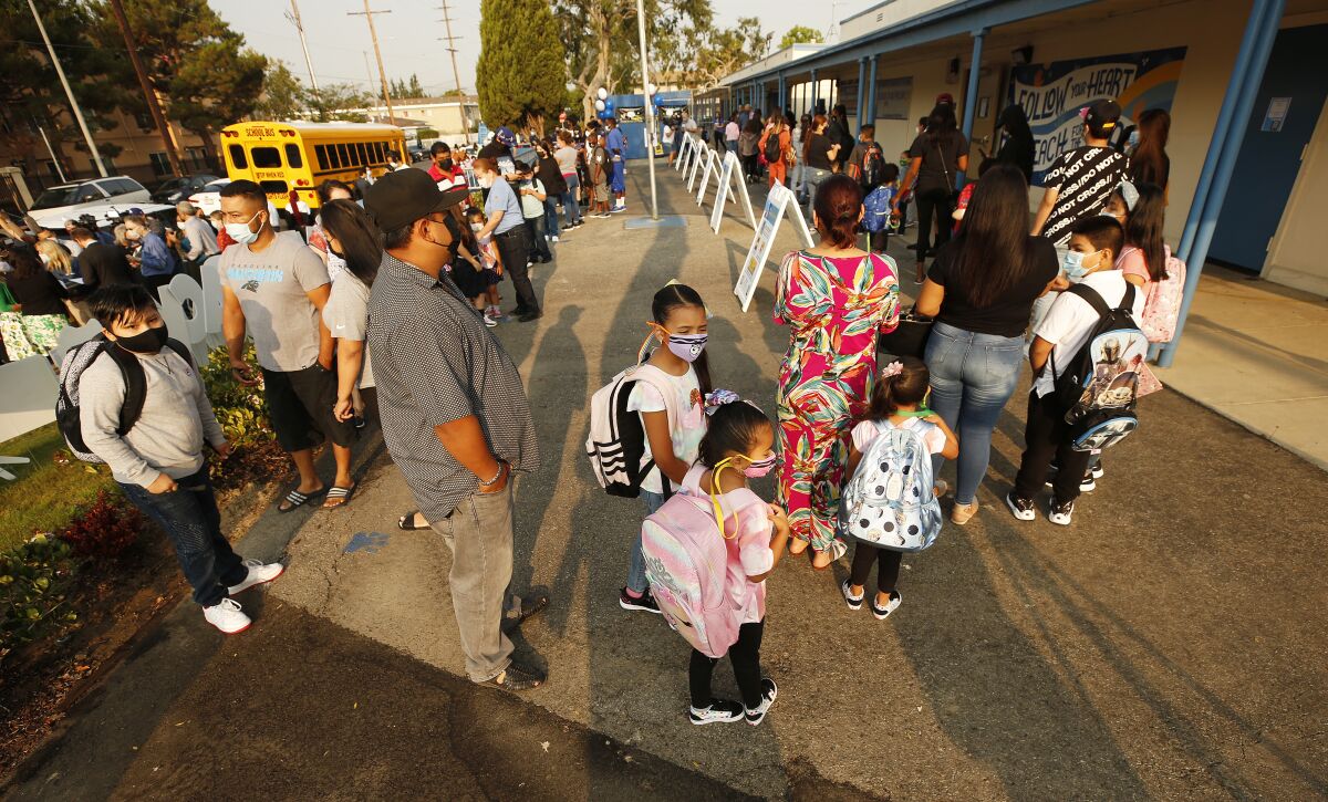 Students and parents wait in line to enter Normont Elementary School in Harbor City on the first day of school. 