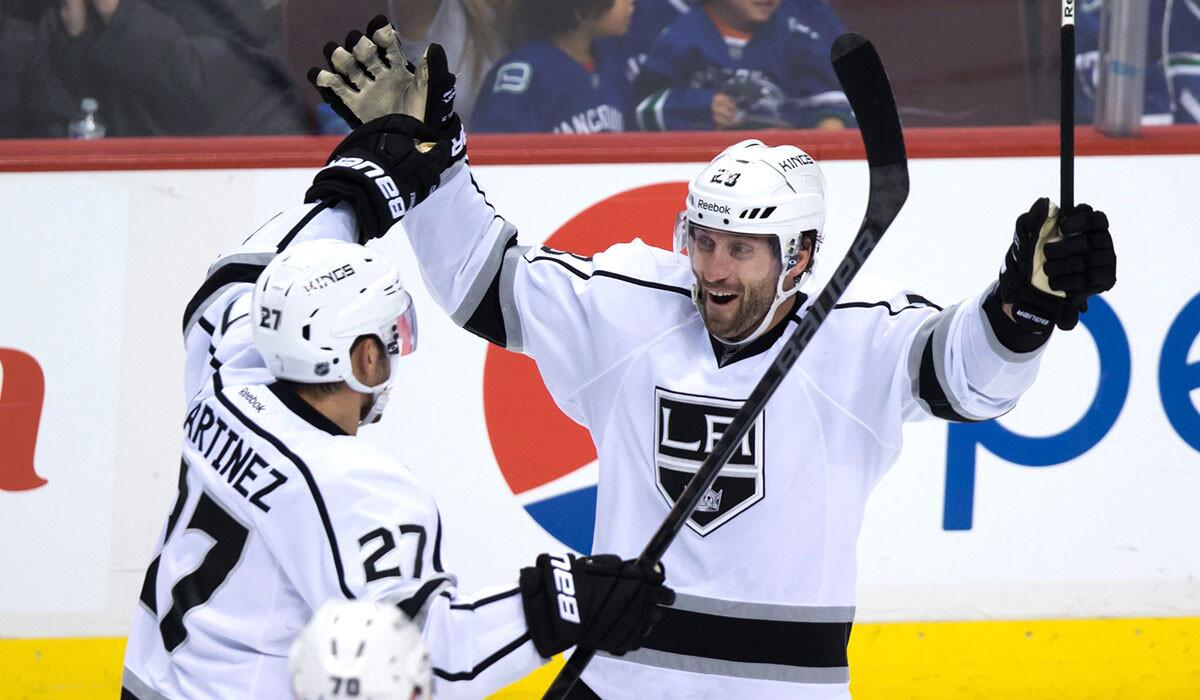 Kings center Jarret Stoll celebrates his game-winning goal against the Canucks with defenseman Alec Martinez (27) on Jan. 1.