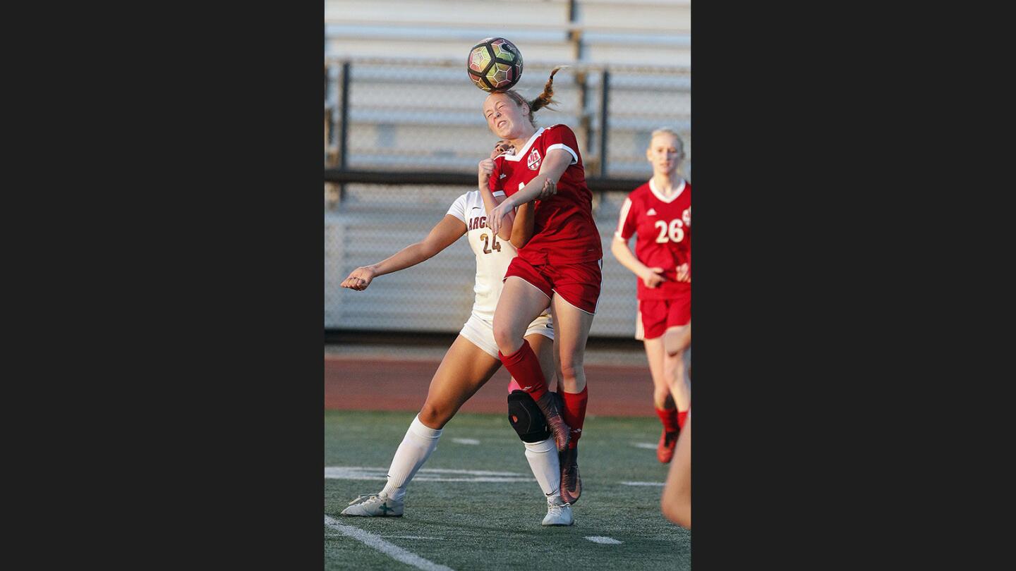Burroughs' Olivia Cashman heads the ball over Arcadia's Mikaila Ainsworth in a Pacific League girls' soccer game at Arcadia High School on Friday, December 22, 2017. Arcadia won the game 1-0.