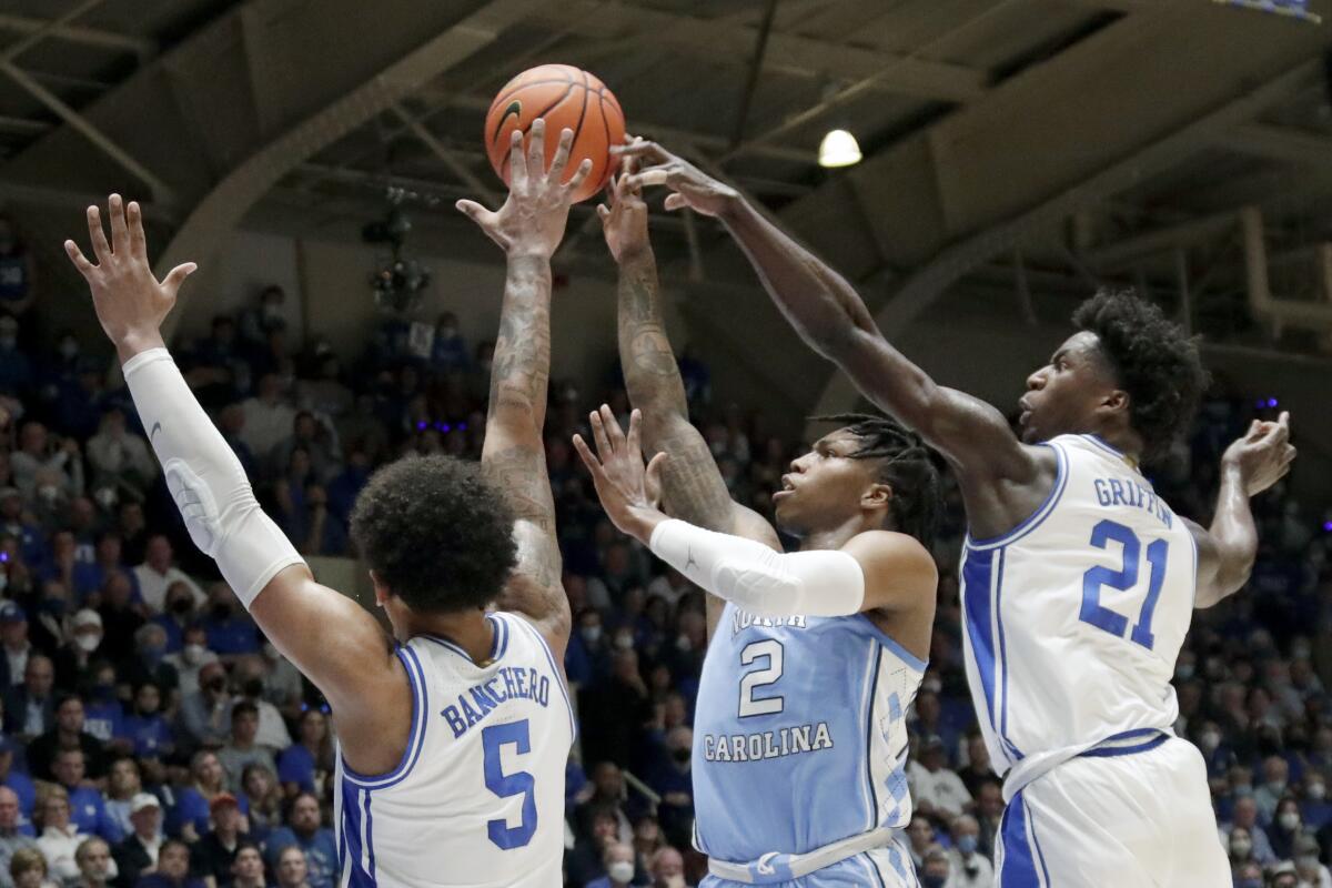 North Carolina's Caleb Love shoots against Duke's Paolo Banchero (5) and AJ Griffin (21) during the first half March 5, 2022.