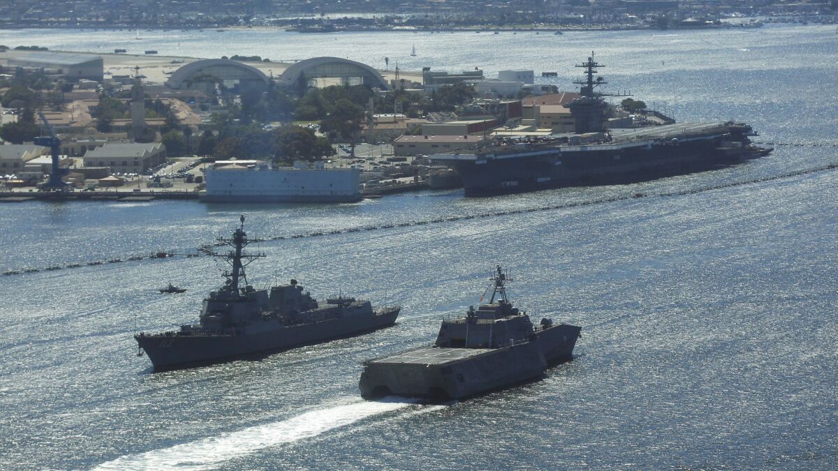 USS John Finn, left, and USS Montgomery pass near USS Theodore Roosevelt at Naval Base Coronado