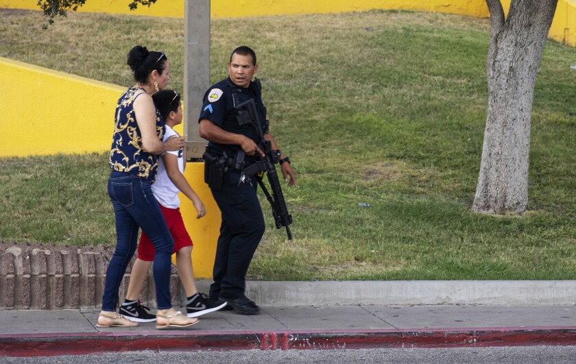 An Odessa police officer escort bystanders away from an area investigated for a shooting in Odessa, Texas, Saturday, Aug. 31, 2019, following a deadly shooting. Several people were dead after a gunman who hijacked a postal service vehicle in West Texas shot more than 20 people, authorities said Saturday. The gunman was killed and a few law enforcement officers were among the injured. (Jacy Lewis/Reporter-Telegram via AP)