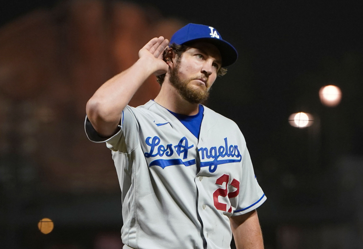 Dodgers pitcher puts his hand to his ear as he walks off the field