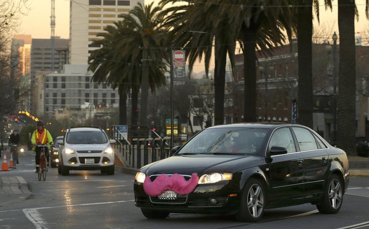 A Lyft car drives crosses Market Street in San Francisco.