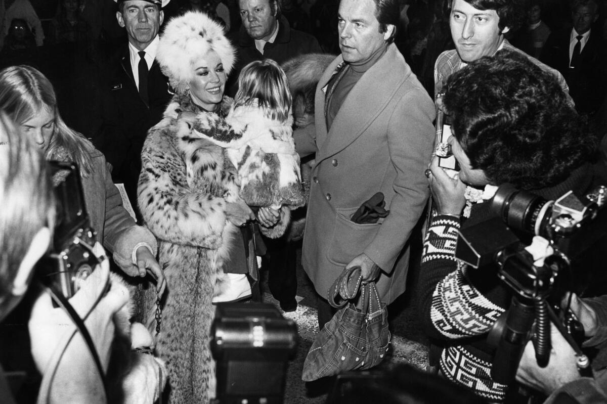 Nov. 28, 1976: Rogert Wagner and wife Natalie Wood, with youngest daughter Courtney, are mobbed by the crowd and photographers as they arrive at the Santa Claus Lane Parade to ride in Santa's sleigh.