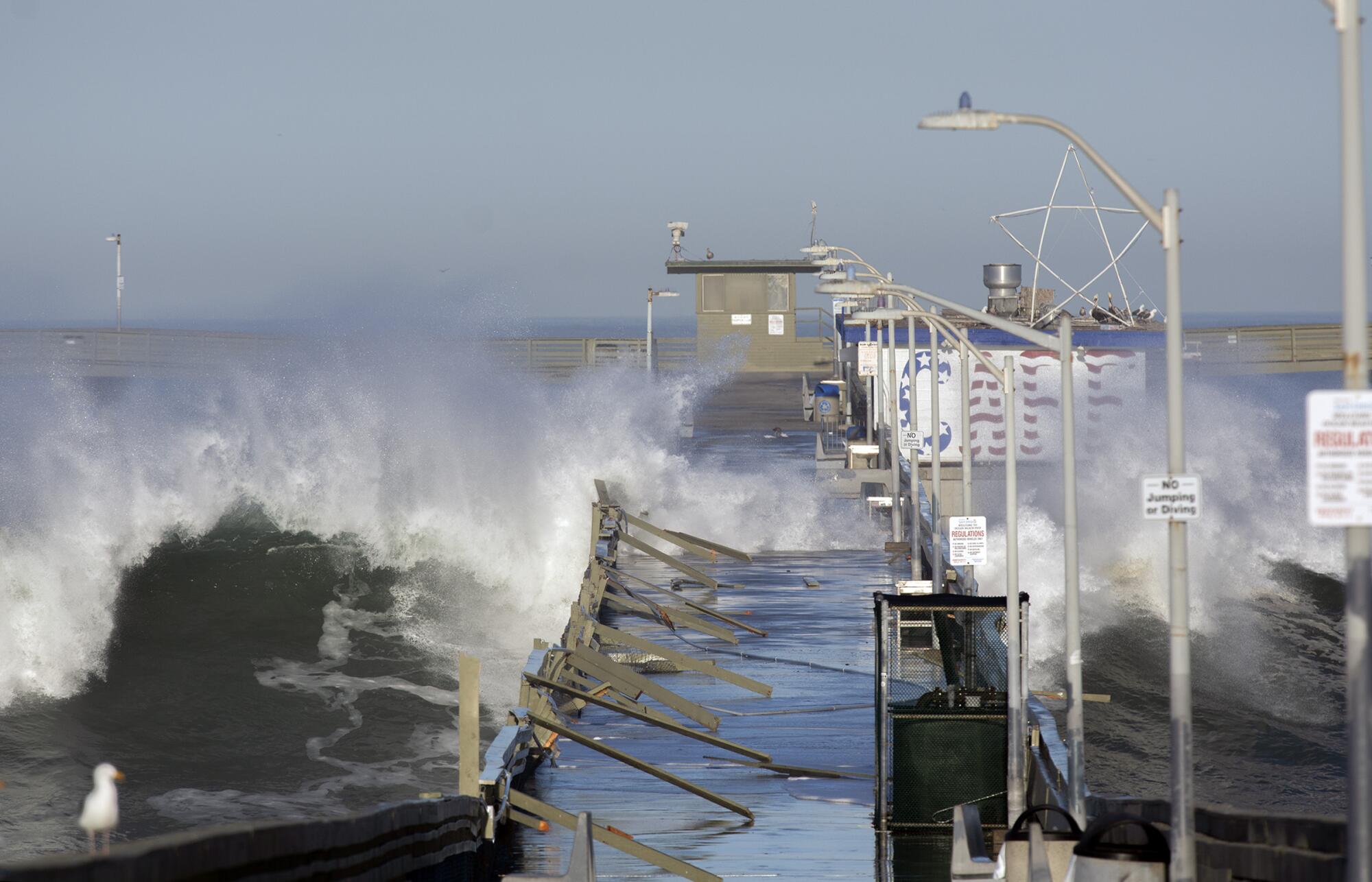 Waves crash over the Ocean Beach pier on Jan. 11, 2021, damaging the pier.