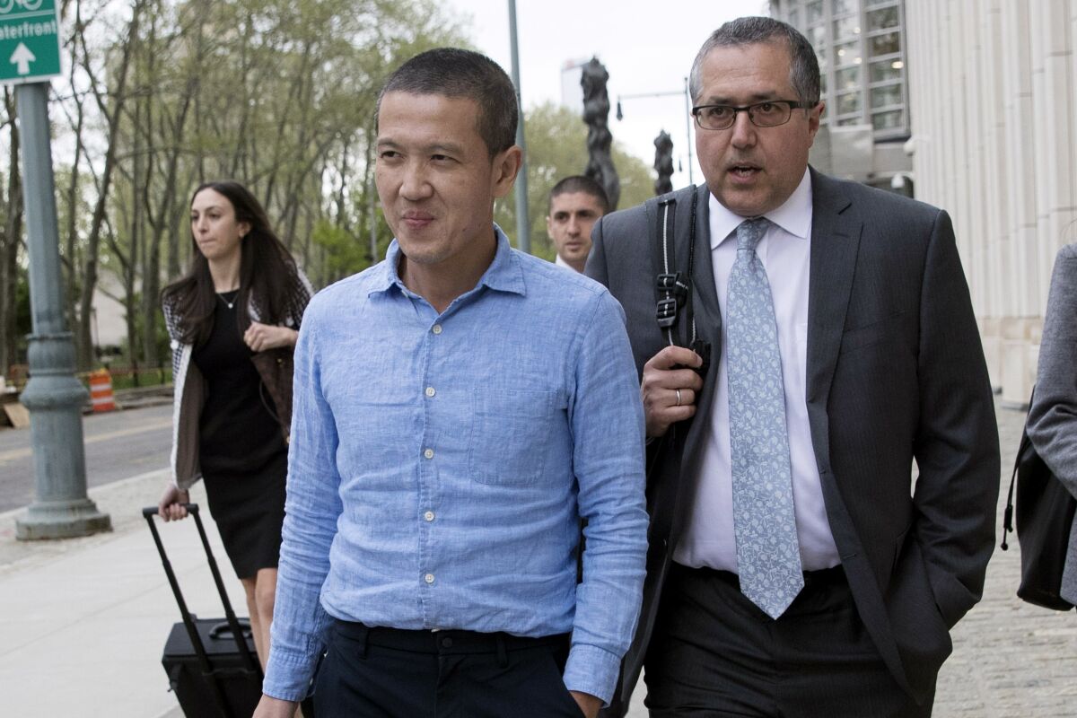 Former Goldman Sachs executive Roger Ng, left, and attorney Marc Agnifilo leave court in 2019