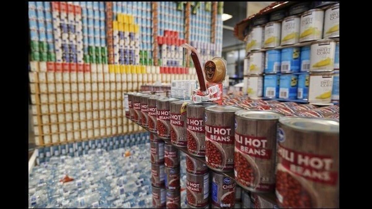 A can man fishes off a pier in the sculpture built by Fluor for the annual Canstruction Orange County. It's on display at John Wayne Airport.