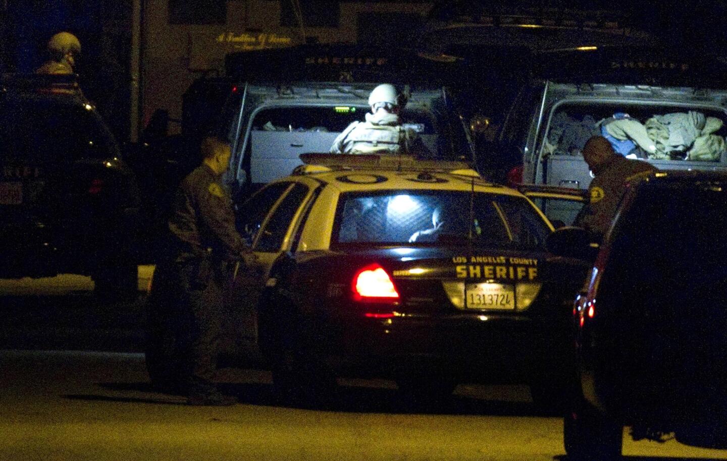 The suspect in an eight-hour standoff in Inglewood sits in the back of a Los Angeles County Sheriff's patrol car. Two females were held hostage after the gunman fired at police officers.