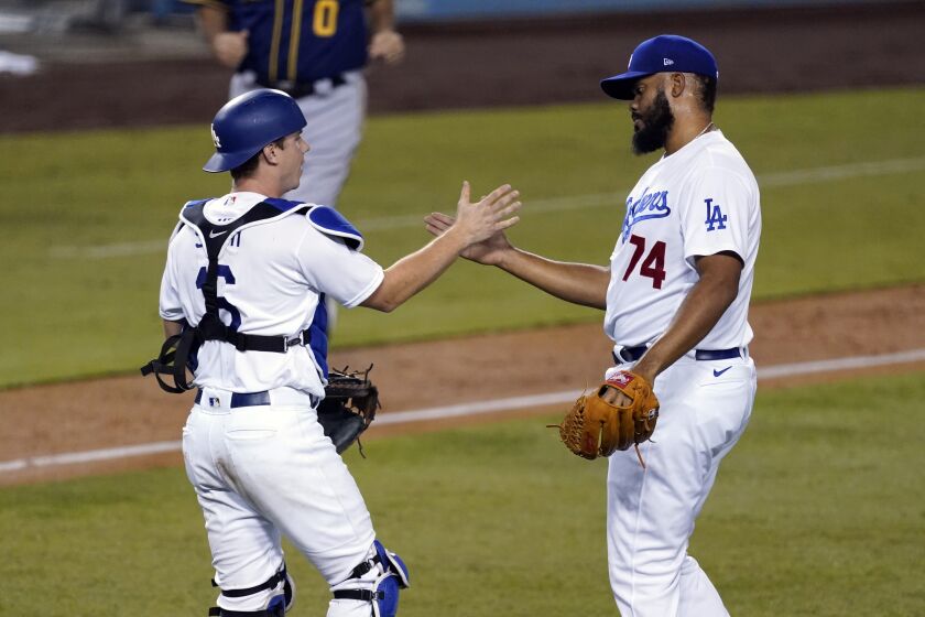 Los Angeles Dodgers relief pitcher Kenley Jansen, right, celebrates a 4-2 win over the Milwaukee Brewers.