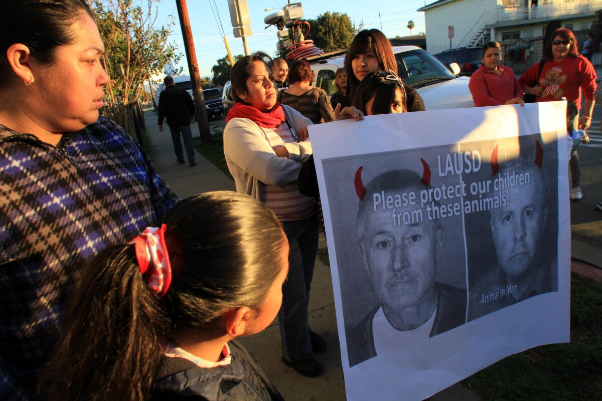 A poster of fired teachers Mark Berndt and Martin Springer, right, greeted students as they arrived at Miramonte Elementary in February 2012.