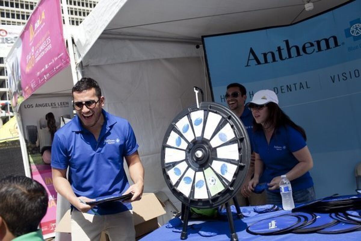 Anthem Blue Cross employees greet people at a Los Angeles enrollment fair in preparation for the Affordable Care Act rollout.