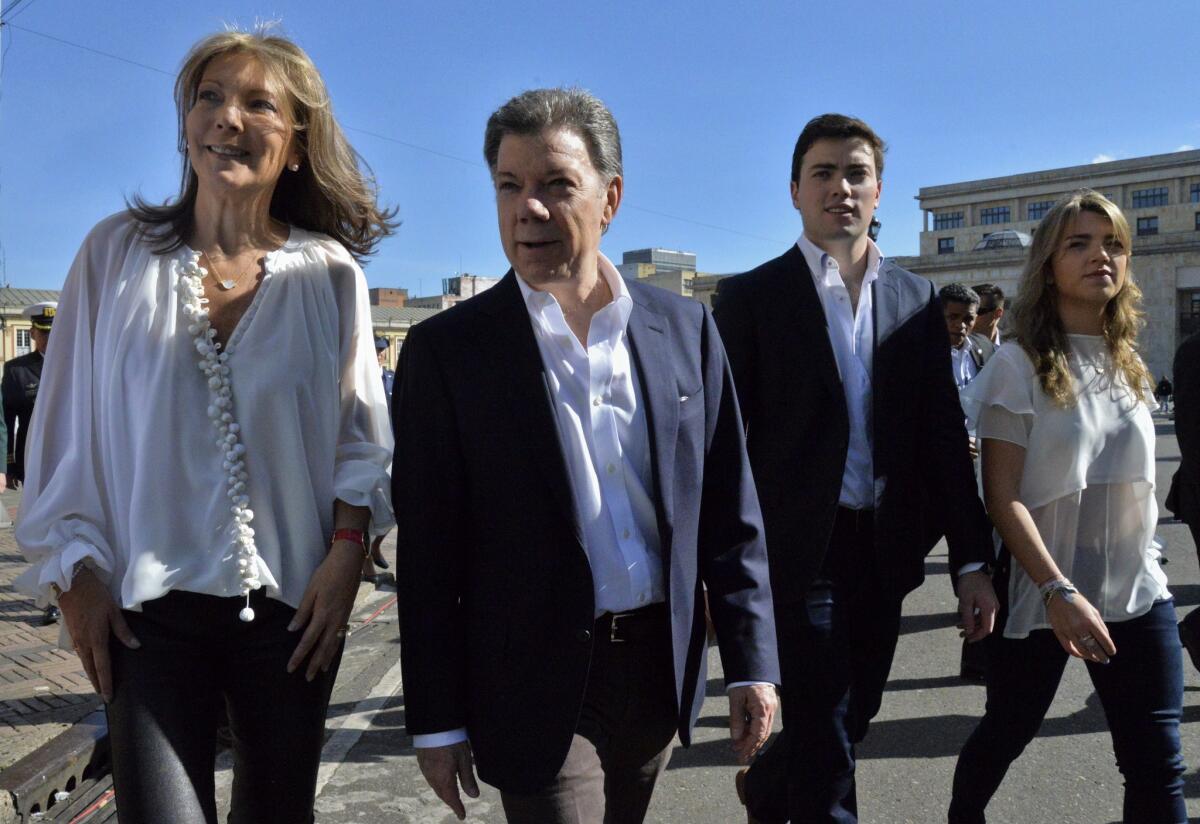 Colombian President Juan Manuel Santos, second from left, wife Maria Clemencia, left, son, Esteban, and daughter, Maria Antonia, walk across Bolivar Square after voting in the presidential election.