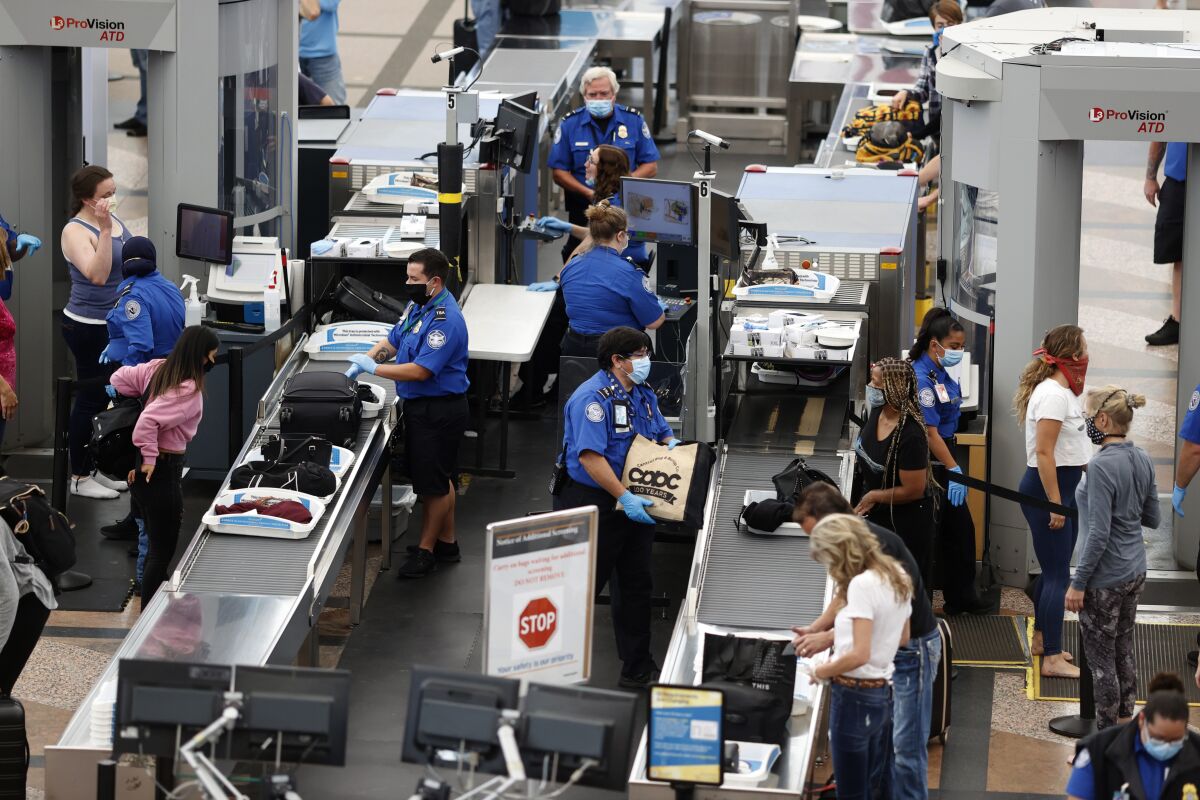 FILE - Transportation Security Administration agents process passengers at the south security checkpoint at Denver International Airport in Denver on June 10, 2020. The chief of the TSA said Tuesday, May 10, 2022, that his agency has quadrupled the number of employees who could bolster screening operations at airports that become too crowded this summer. (AP Photo/David Zalubowski, File)