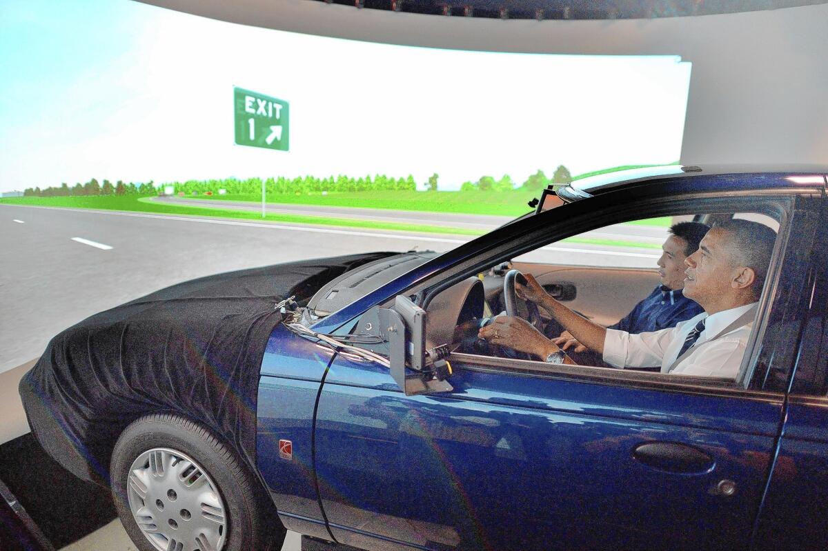 President Obama drives an automobile simulator at the Turner-Fairbank Highway Research Center in McLean, Va.