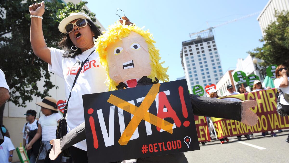 Emma Torres of Van Nuys holds a Donald Trump piñata while participating in the May Day rally in downtown Los Angeles on May 1, 2016.