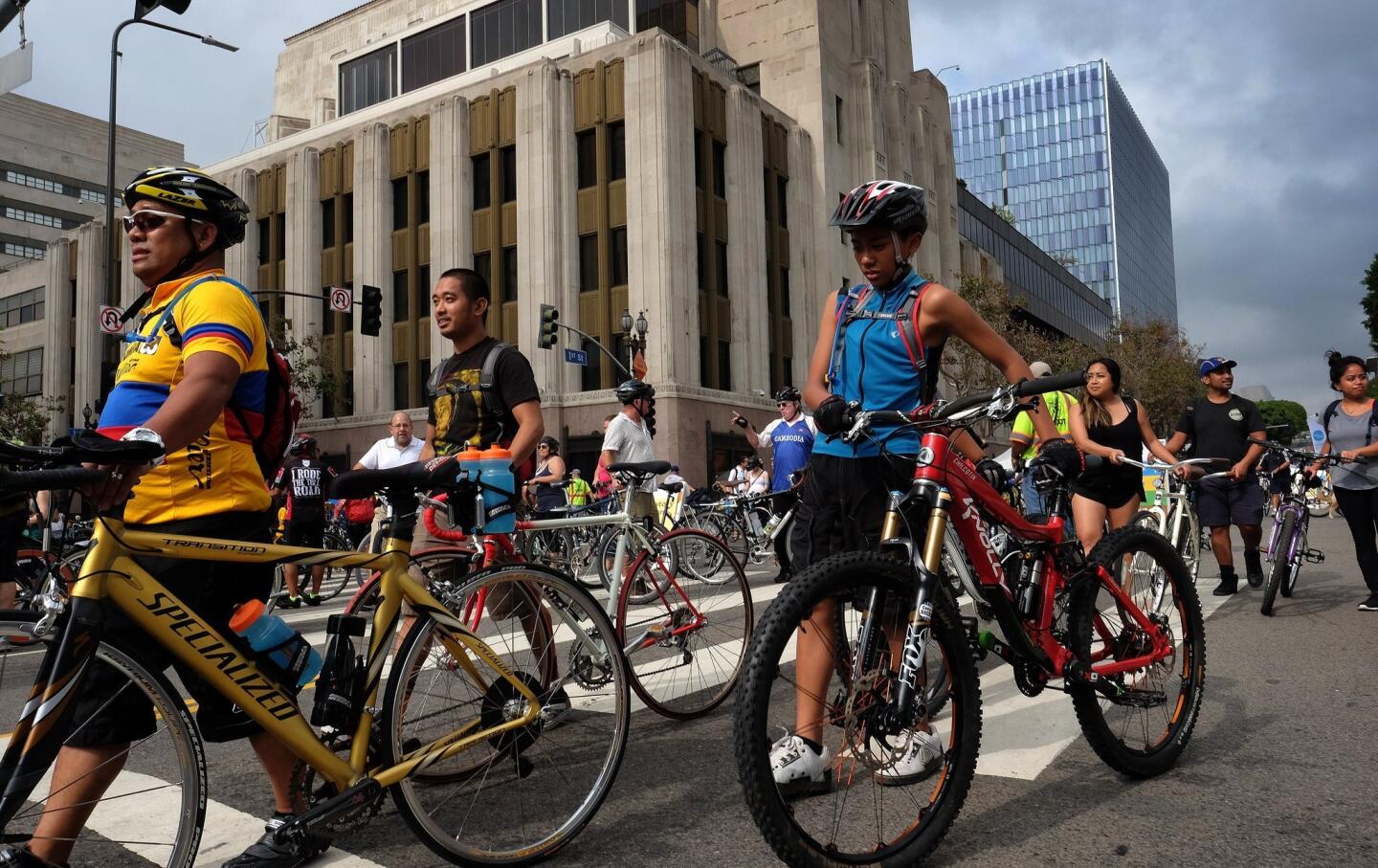 Cyclists walk their bikes through an intersection of downtown Los Angeles on Sunday, Oct. 18, 2015. It's a car free day in parts of LA and some six miles of streets in and around downtown Los Angeles are closed to motor vehicles as the city's fifth anniversary celebration of the CicLAvia festival opens the lanes to cyclists. (AP Photo/Richard Vogel)