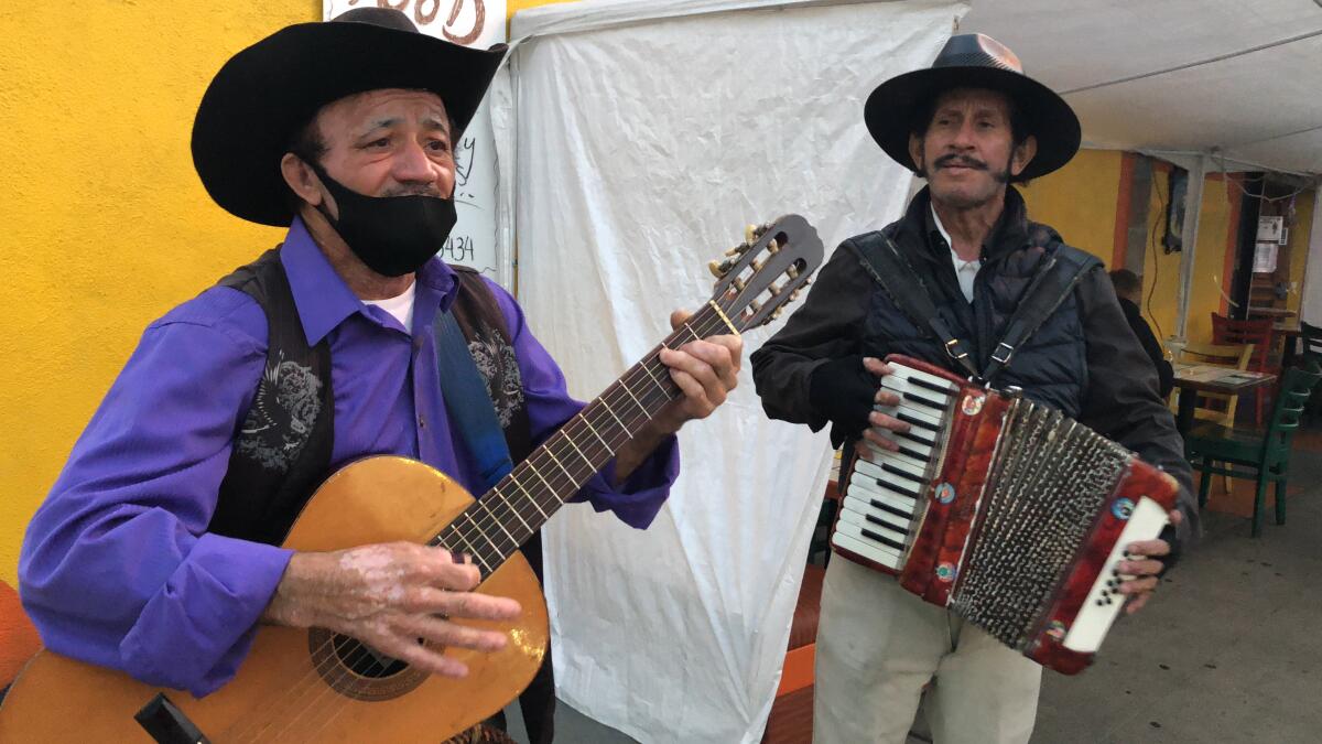 La música norteña suena en las voces y los instrumentos de Elías Flores y César Villanueva (derecha).