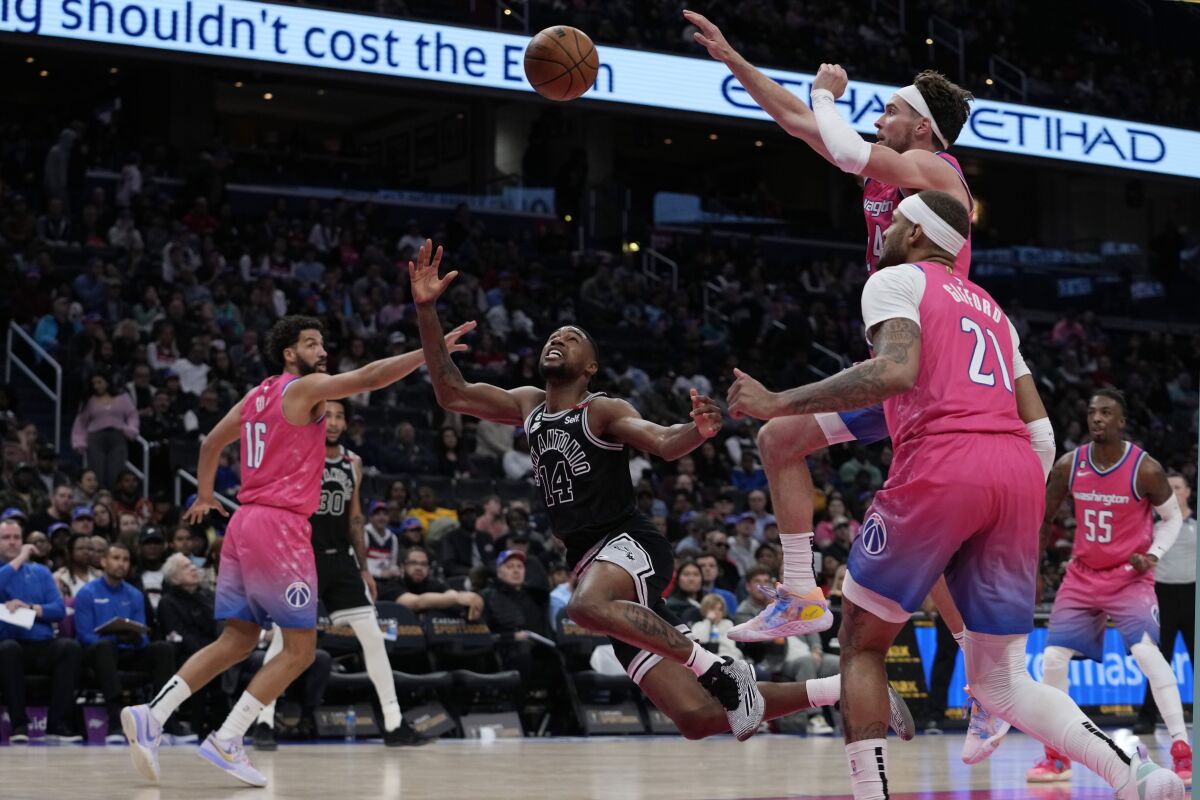 San Antonio Spurs guard Blake Wesley (14) goes up against Washington Wizards forward Anthony Gill (16), center Daniel Gafford (21) and forward Corey Kispert, top right, during the second half of an NBA basketball game Friday, March 24, 2023, in Washington. (AP Photo/Carolyn Kaster)