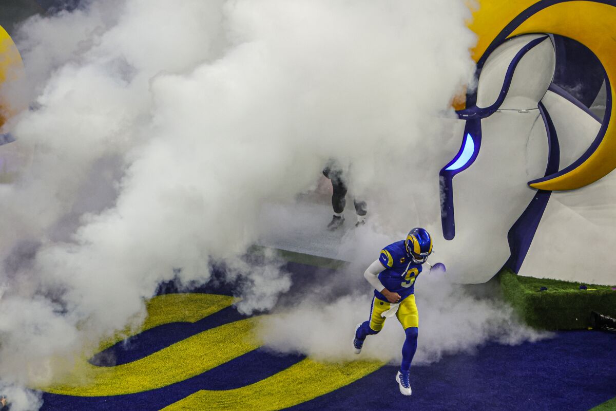 Rams quarterback Matthew Stafford runs through a billow of smoke and onto the field for the playoffs.