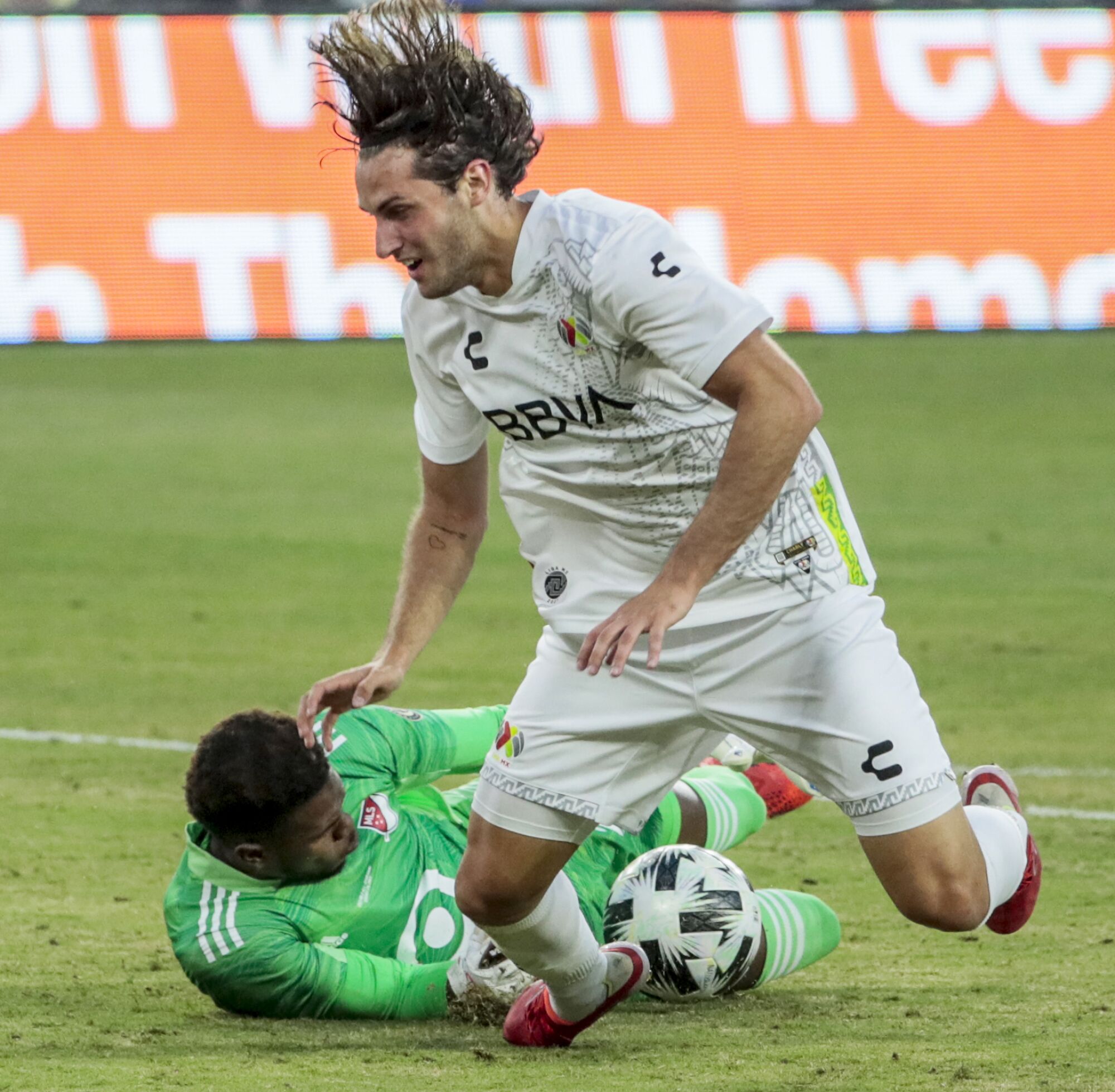 MLS goalie Andre Blake knocks the ball from Liga MX forward Santiago Giminez