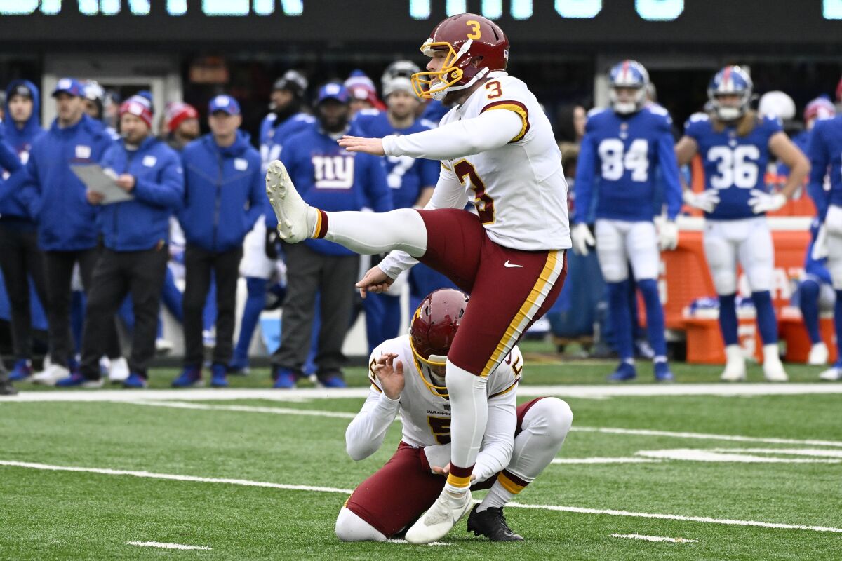 FILE - Washington kicker Joey Slye (3) kicks a field goal against the New York Giants during the second quarter of an NFL football game, Sunday, Jan. 9, 2022, in East Rutherford, N.J. The Washington Commanders have re-signed kicker Joey Slye to a two-year deal that could be worth up to $5 million with $2 million guaranteed, according to a person with knowledge of the move. The person spoke to The Associated Press on condition of anonymity Monday, April 11, 2022, because the deal had not been announced. Slye had previously been tendered a $2.4 million qualifying offer as a restricted free agent .(AP Photo/Bill Kostroun, File)