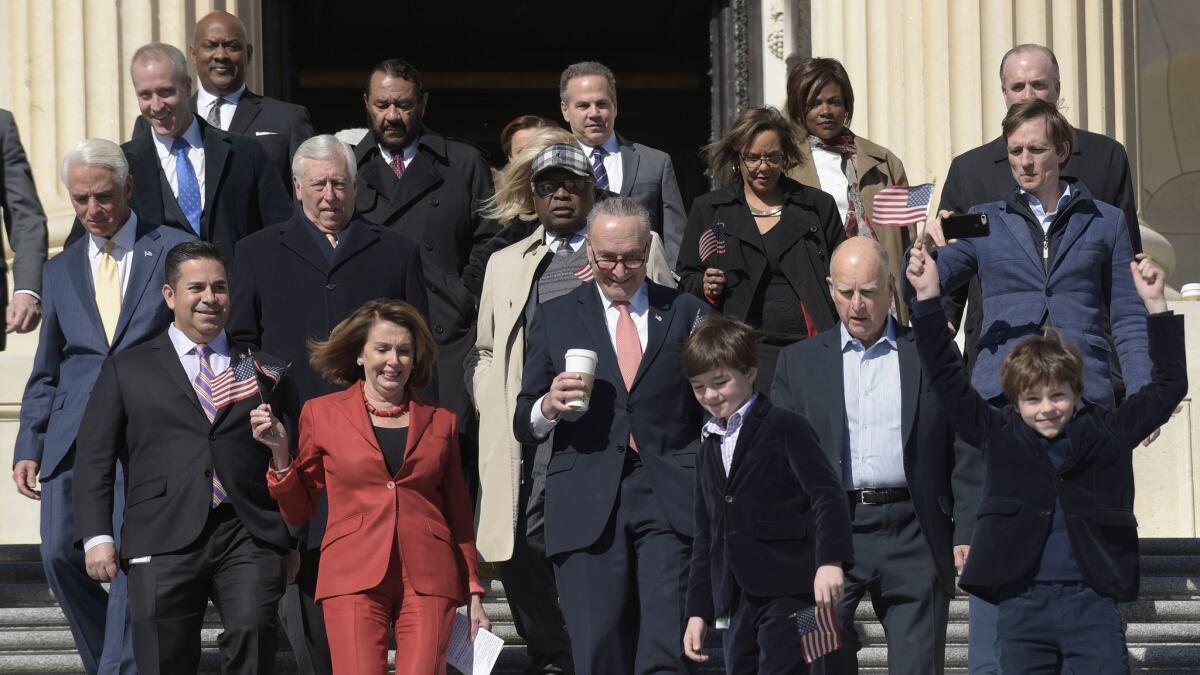 House Minority Leader Nancy Pelosi (D-San Francisco), front left in red, Senate Minority Leader Charles E. Schumer (D-N.Y.) and Gov. Jerry Brown are joined by other Democrats at the U.S. Capitol for a rally marking seven years of the Affordable Care Act.