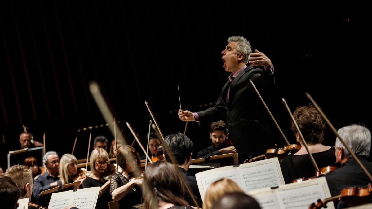 David Lockington conducts the Pasadena Symphony at the Ambassador Auditorium in April. The musicians have voted to authorize a strike as soon as this month, their union said.