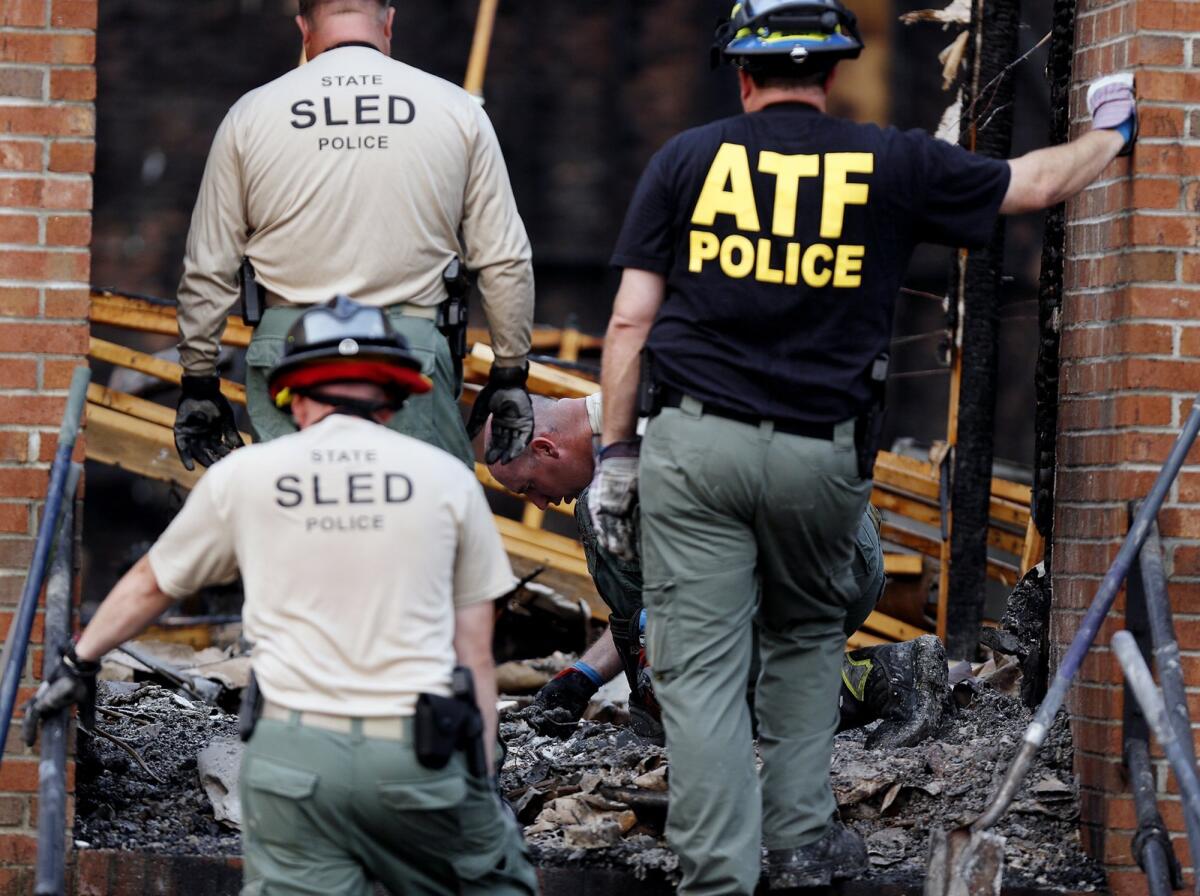 Investigators from the Bureau of Alcohol, Tobacco, Firearms and Explosives and the South Carolina Law Enforcement Division sift through charred debris inside the Mount Zion African Methodist Episcopal Church in Greeleyville, S.C., on Wednesday morning.